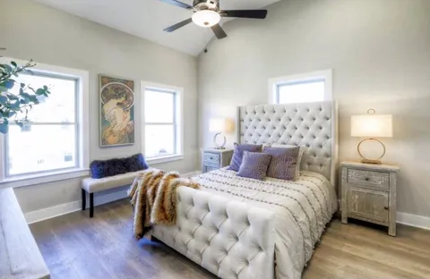 a bedroom with a large bed and a chandelier