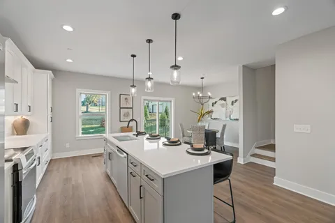 a open kitchen with stainless steel appliances granite countertop a sink stove and wooden floor