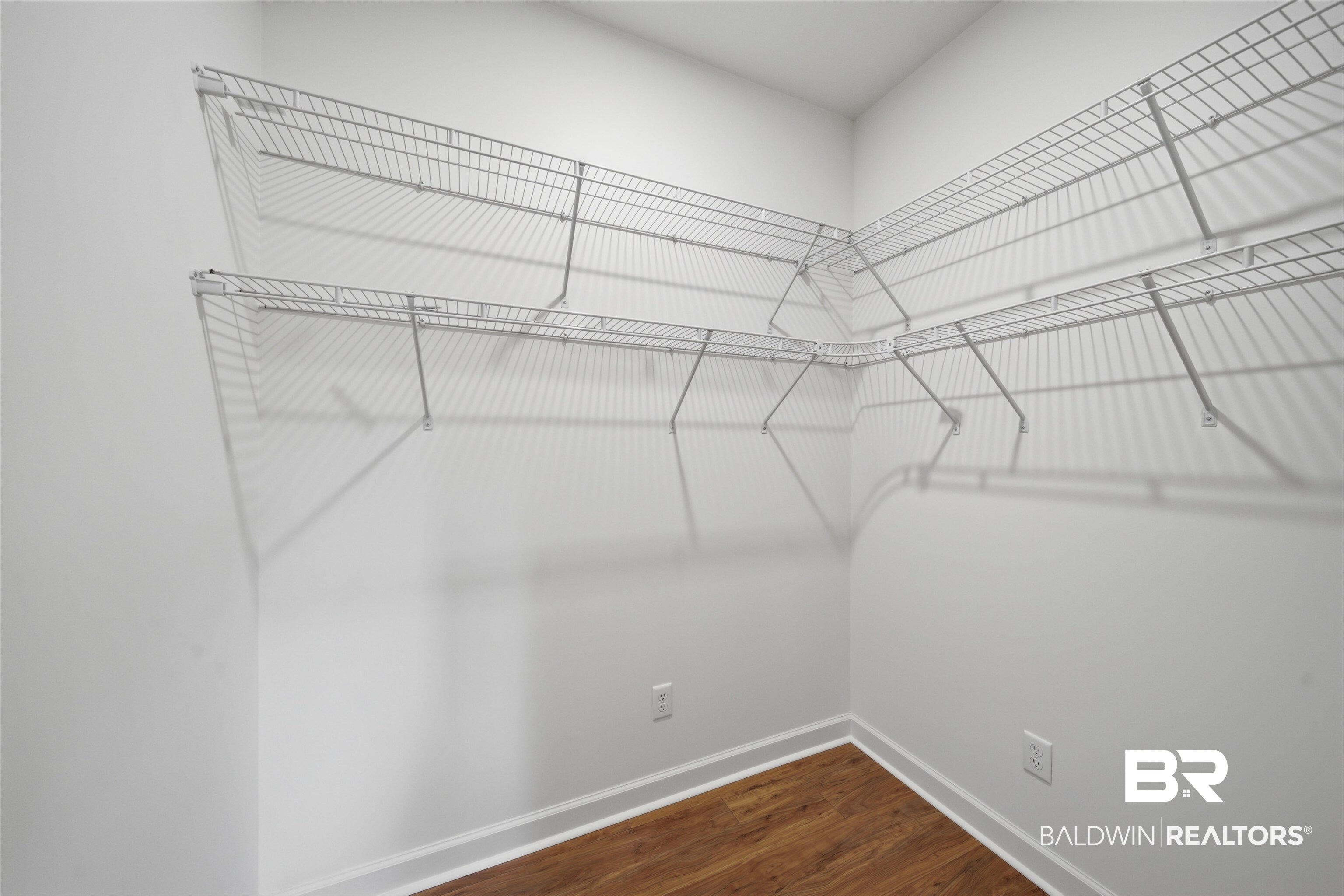 14128 Jackson Lane Foley, AL 36535 - Photo 24 of 36 Corner closet with white wire shelving, bright white walls, and wood-finish flooring