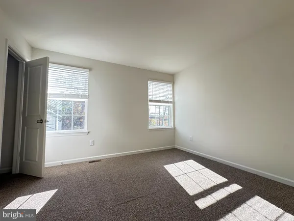 an empty room with windows and closet