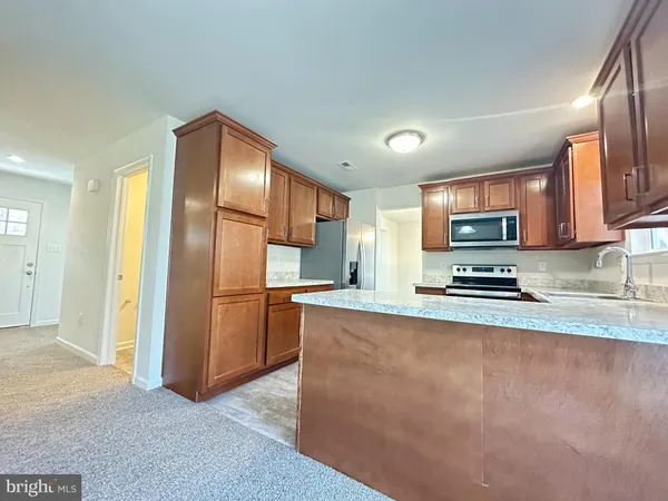 a kitchen with stainless steel appliances granite countertop a refrigerator a stove top oven a sink and dishwasher