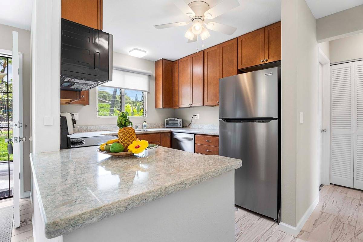 The kitchen features gorgeous shaker-style cabinets with ample storage, quartz counters, and new stainless steel appliances.