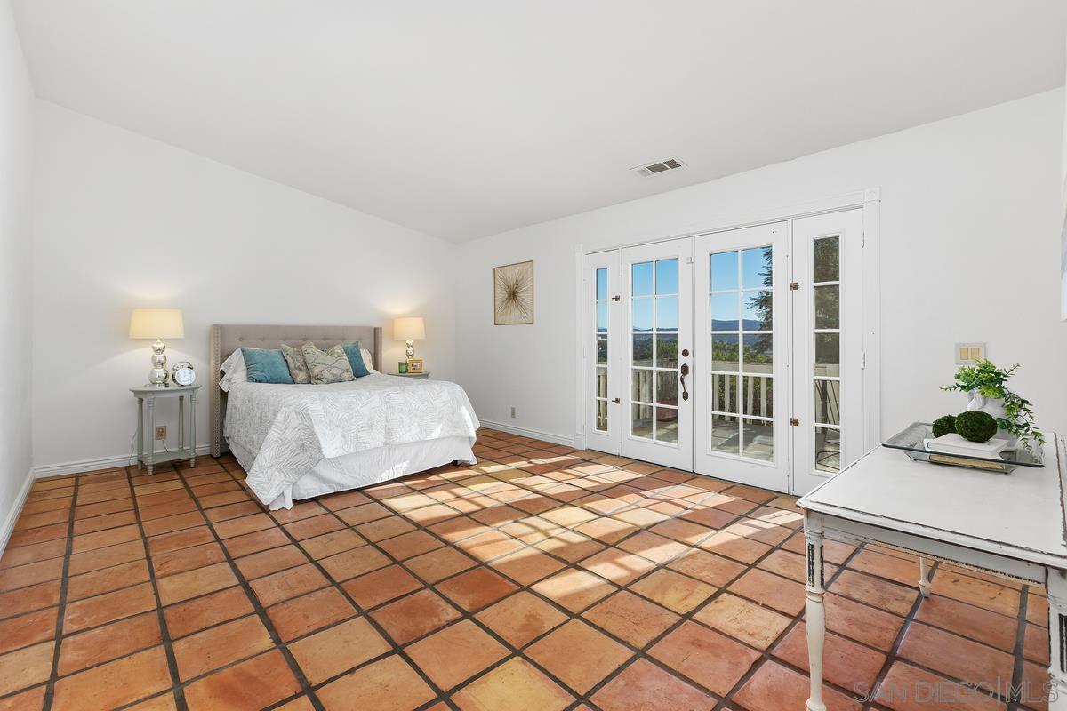 13747 Little Pond Road Valley Center, CA 92082 - Photo 20 of 39 a bedroom with a bed and a large window