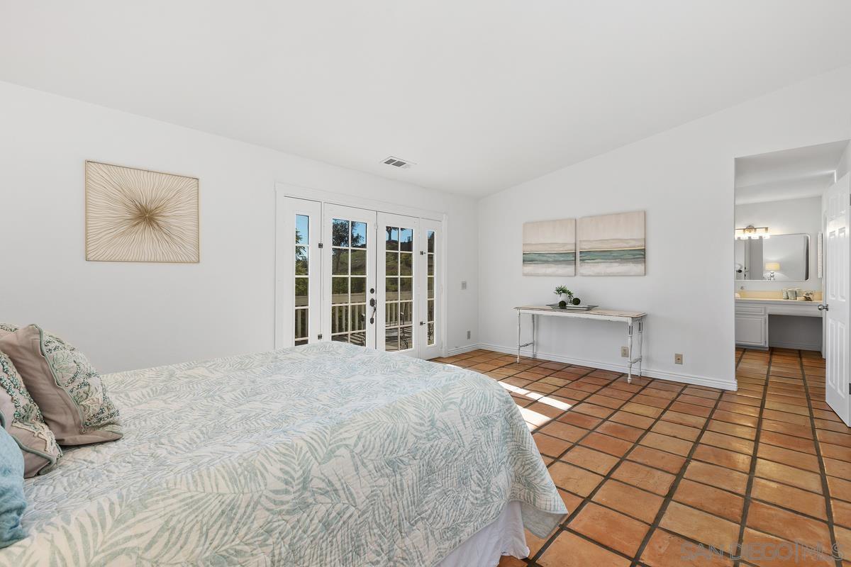13747 Little Pond Road Valley Center, CA 92082 - Photo 21 of 39 a large bedroom with a bed and a window