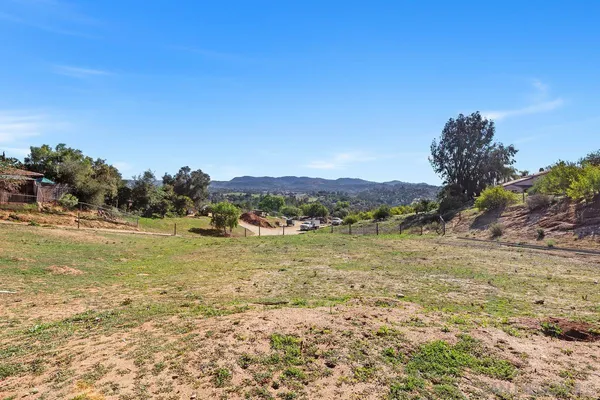 a view of a field with trees in background