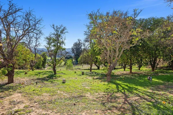 an aerial view of residential house with yard and mountain view in back