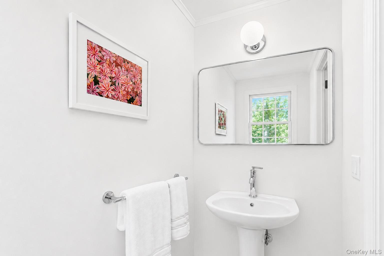 275 Pinewood Road Cutchogue, NY 11935 - Photo 27 of 45 Pedestal sink with chrome faucet, wall-mounted mirror with rounded corners, and a chrome towel bar