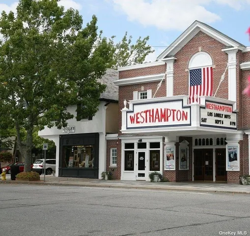 a view of a brick building with a large window and a man seat
