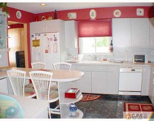 114 South Cliff Road Colonia, NJ 07067 - Photo 5 of 10 a kitchen with a sink window and white cabinets