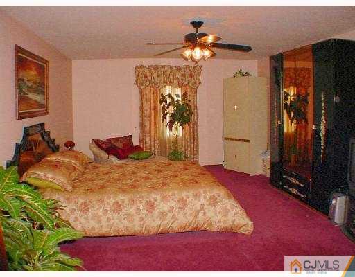 114 South Cliff Road Colonia, NJ 07067 - Photo 7 of 10 a bedroom with a bed and a chandelier