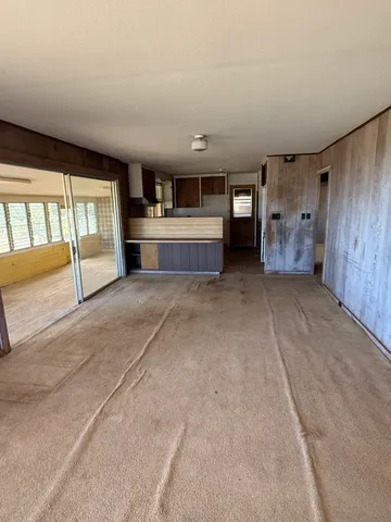 a view of an empty room with a fireplace and windows