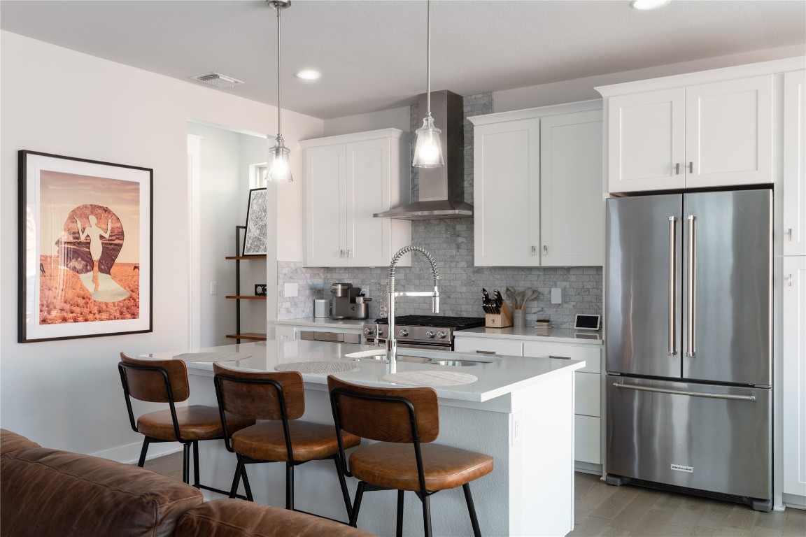2906 Webberville Road, Unit 2 Austin, TX 78702 - Photo 3 of 21 a kitchen with stainless steel appliances granite countertop a refrigerator a sink a stove a dining table and chairs