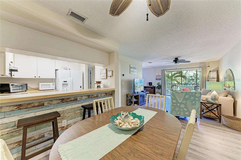 756 White Pine Tree Road, Unit 210 Venice, FL 34285 - Photo 11 of 55 a large kitchen with a table chairs wooden floor and a window