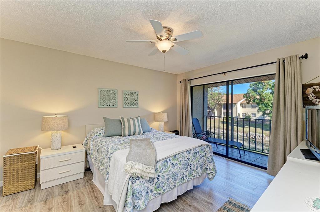 756 White Pine Tree Road, Unit 210 Venice, FL 34285 - Photo 15 of 55 a bedroom with a large bed and a chandelier