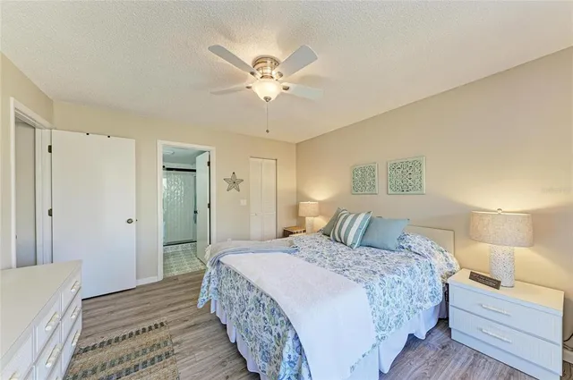 a bedroom with a large bed a flat tv screen and a dresser