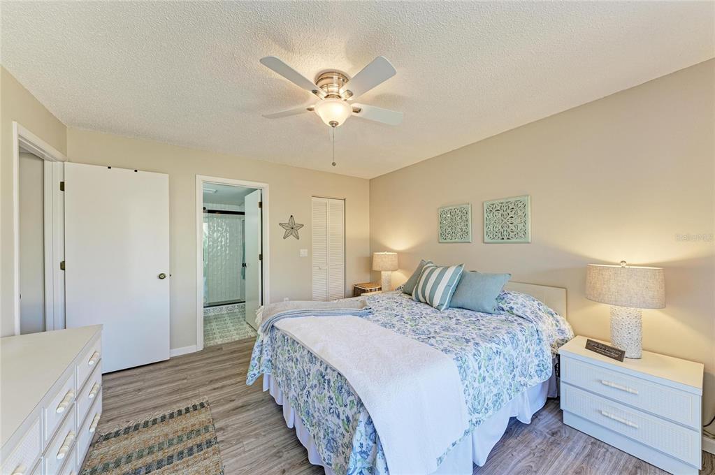 756 White Pine Tree Road, Unit 210 Venice, FL 34285 - Photo 17 of 55 a bedroom with a large bed and a chandelier