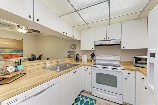 a large kitchen with a table chairs wooden floor and a window