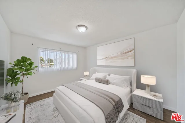 a bedroom with bed and a potted plant