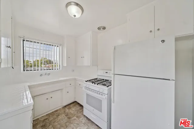a kitchen with white cabinets and white appliances