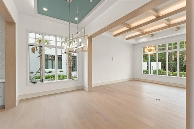 a view of an entryway of a room with a chandelier fan and windows