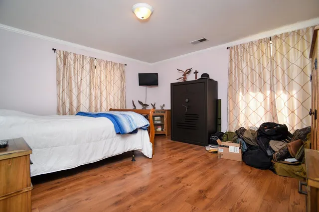 a bedroom with a bed dresser and a window