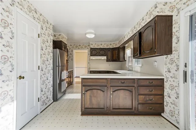 a kitchen with stainless steel appliances granite countertop a refrigerator and a stove top oven