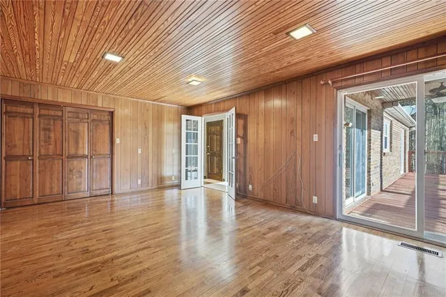 a view of an empty room with wooden floor and entryway