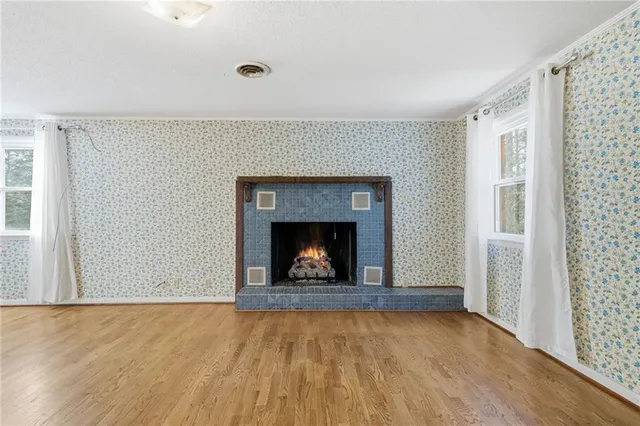 a view of an empty room with a fireplace and a window