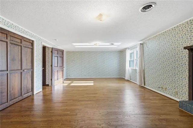 a view of an empty room with wooden floor