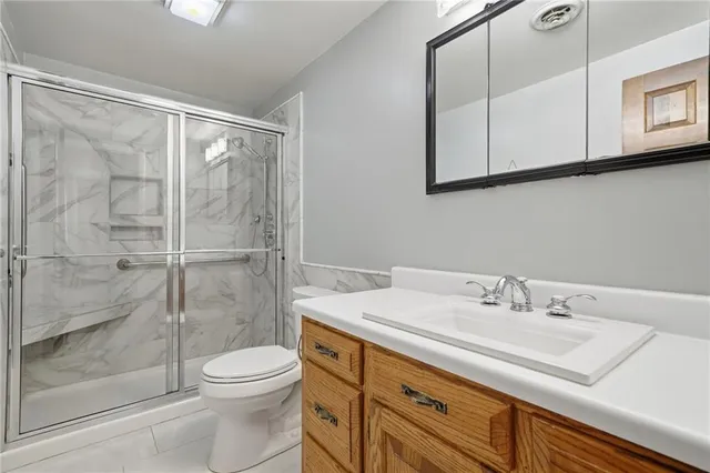 a bathroom with a sink a toilet and shower