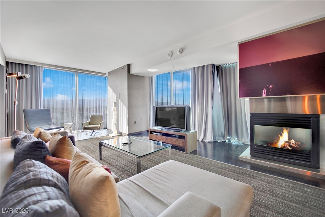 4381 West Flamingo Road, Unit 1901 Las Vegas, NV 89103 - Photo 6 of 18 Living area with a glass covered fireplace, floor