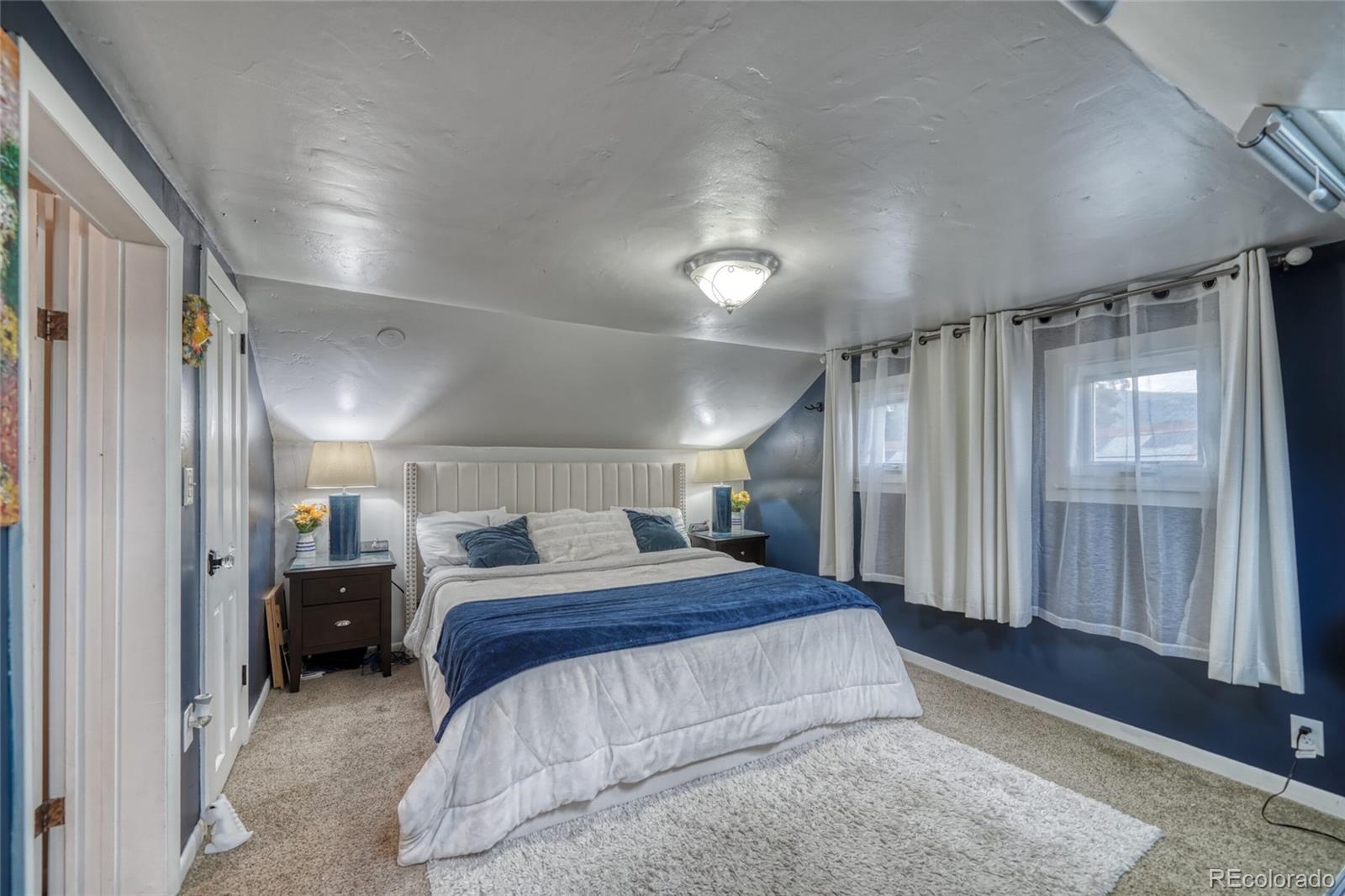 306 Elm Street Leadville, CO 80461 - Photo 23 of 42 a spacious bedroom with a bed and a large mirror