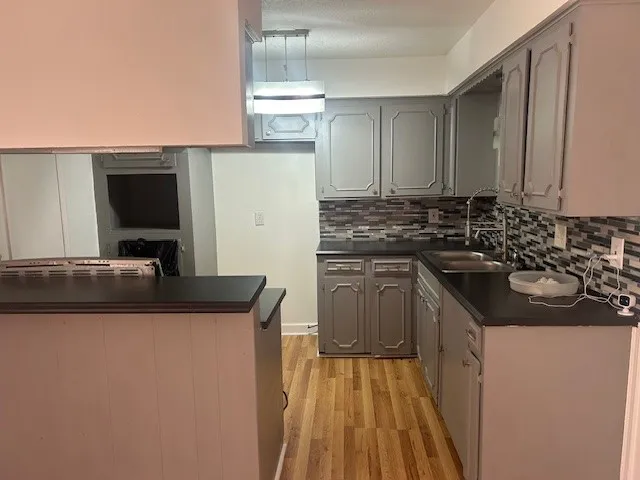 a kitchen with a sink and a stove top oven