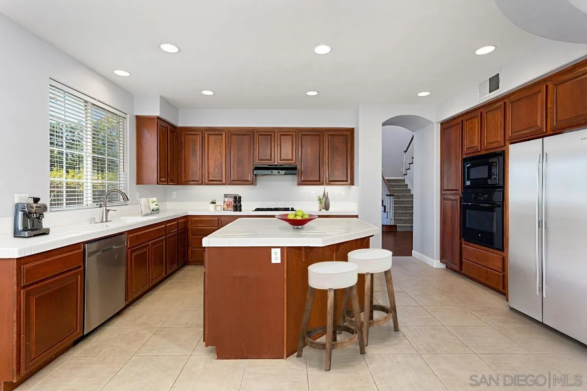 536 Echo Lane San Marcos, CA 92078 - Photo 4 of 24 a kitchen with stainless steel appliances granite countertop a sink a stove a refrigerator and a refrigerator