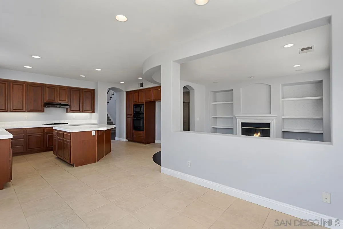536 Echo Lane San Marcos, CA 92078 - Photo 10 of 24 a large kitchen with a refrigerator a stove top oven a sink and dishwasher with wooden floor