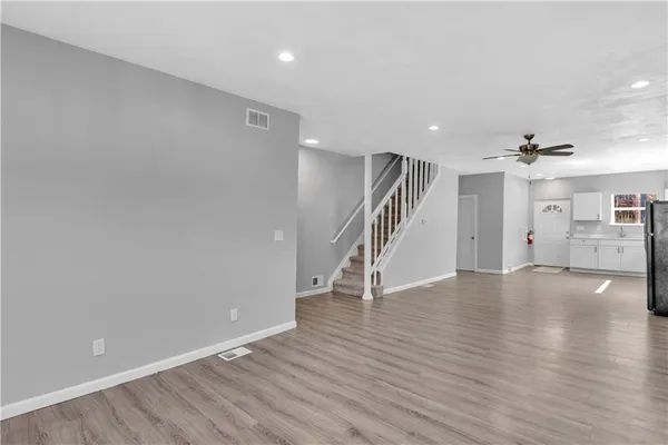 an empty room with wooden floor and staircase