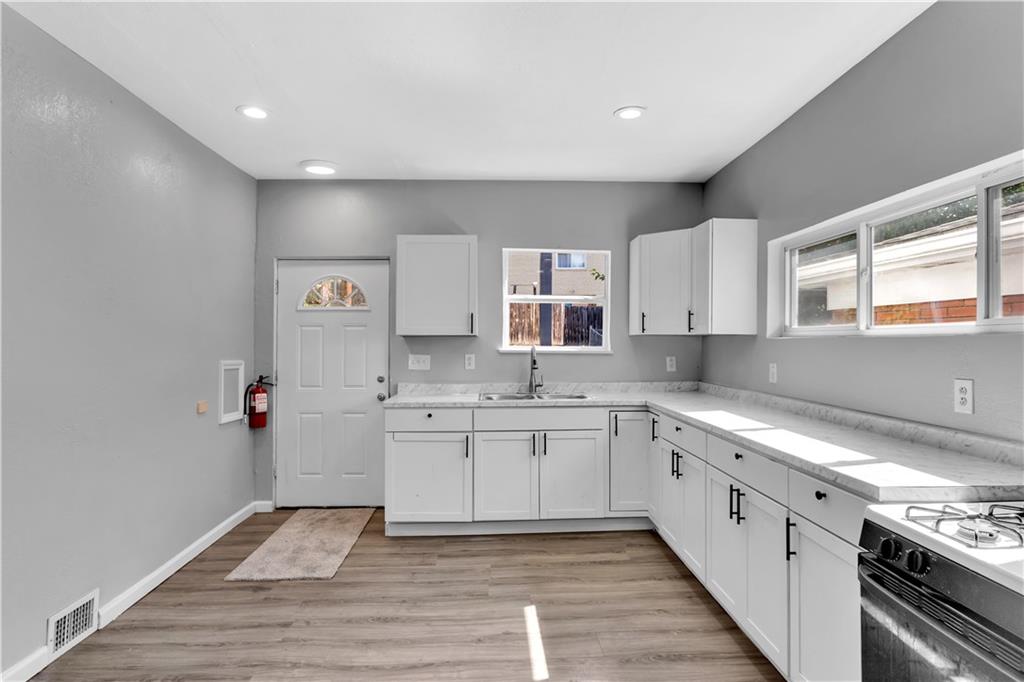 1406 Broadway Avenue McKees Rocks, PA 15136 - Photo 10 of 28 a kitchen with stainless steel appliances granite countertop a sink and cabinets with wooden floor