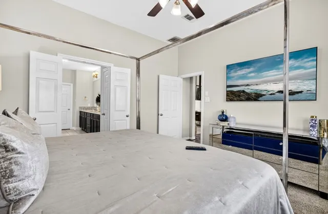 a spacious bedroom with a bed and a chandelier