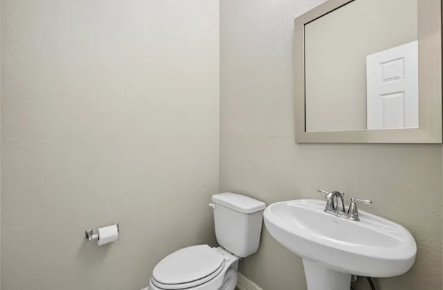 a white toilet sitting next to a bathroom sink