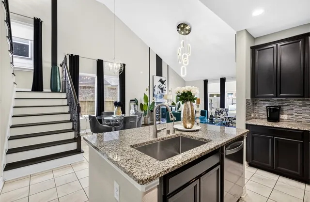 a kitchen with granite countertop a sink and cabinets