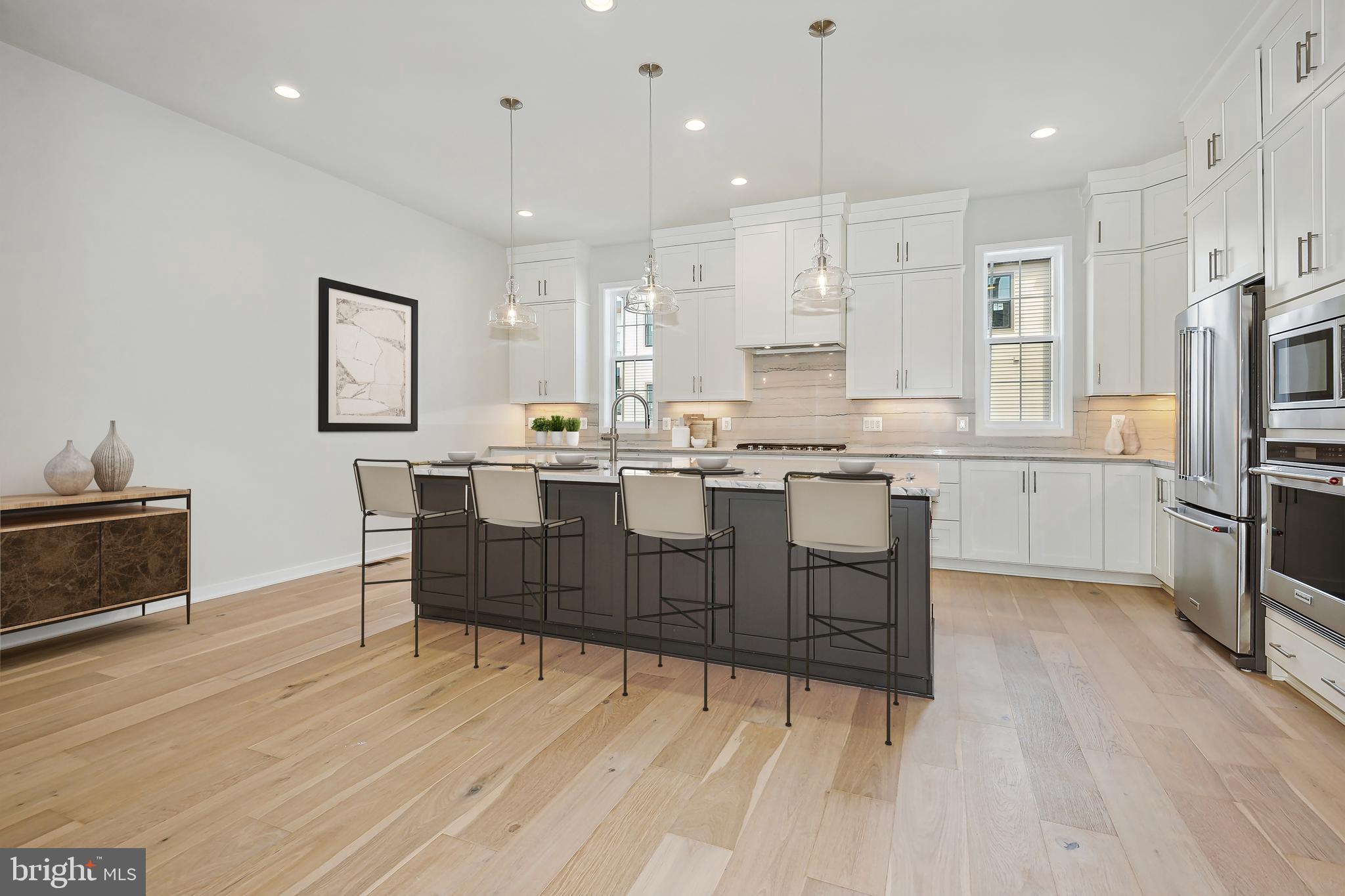 a kitchen with stainless steel appliances kitchen island granite countertop a sink and a refrigerator