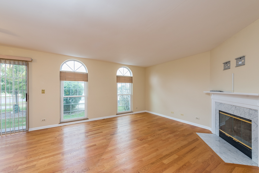 34321 Homestead Road Gurnee, IL 60031 - Photo 7 of 30 an empty room with wooden floor fireplace and windows