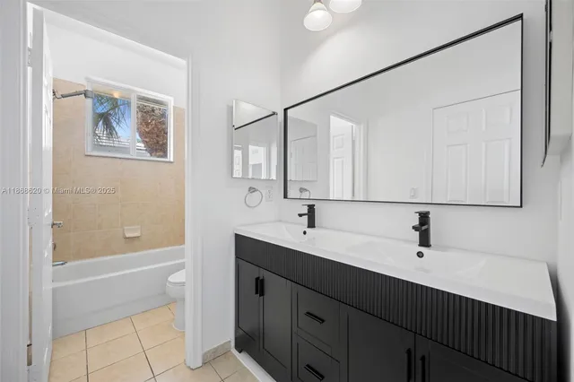 a bathroom with a double vanity sink a mirror and a bathtub