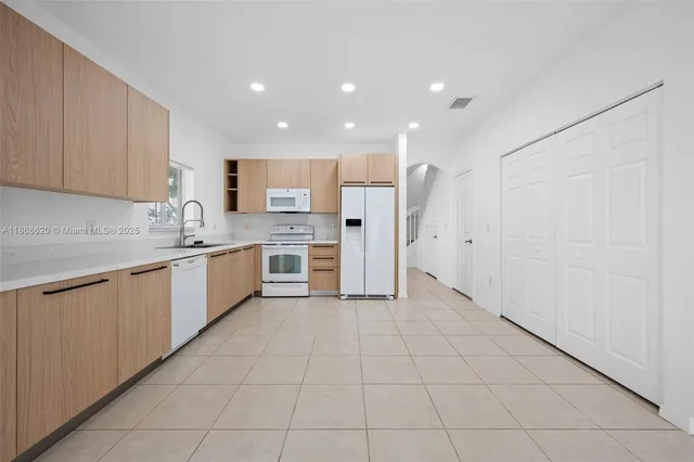 a kitchen with a sink a refrigerator and cabinets