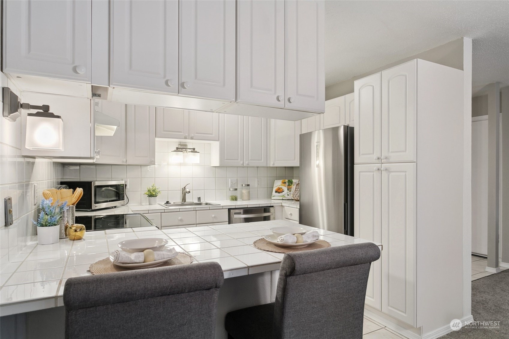 1425 South Puget Drive, Unit H5 Renton, WA 98055 - Photo 11 of 29 a kitchen with stainless steel appliances a refrigerator a sink a stove and white cabinets