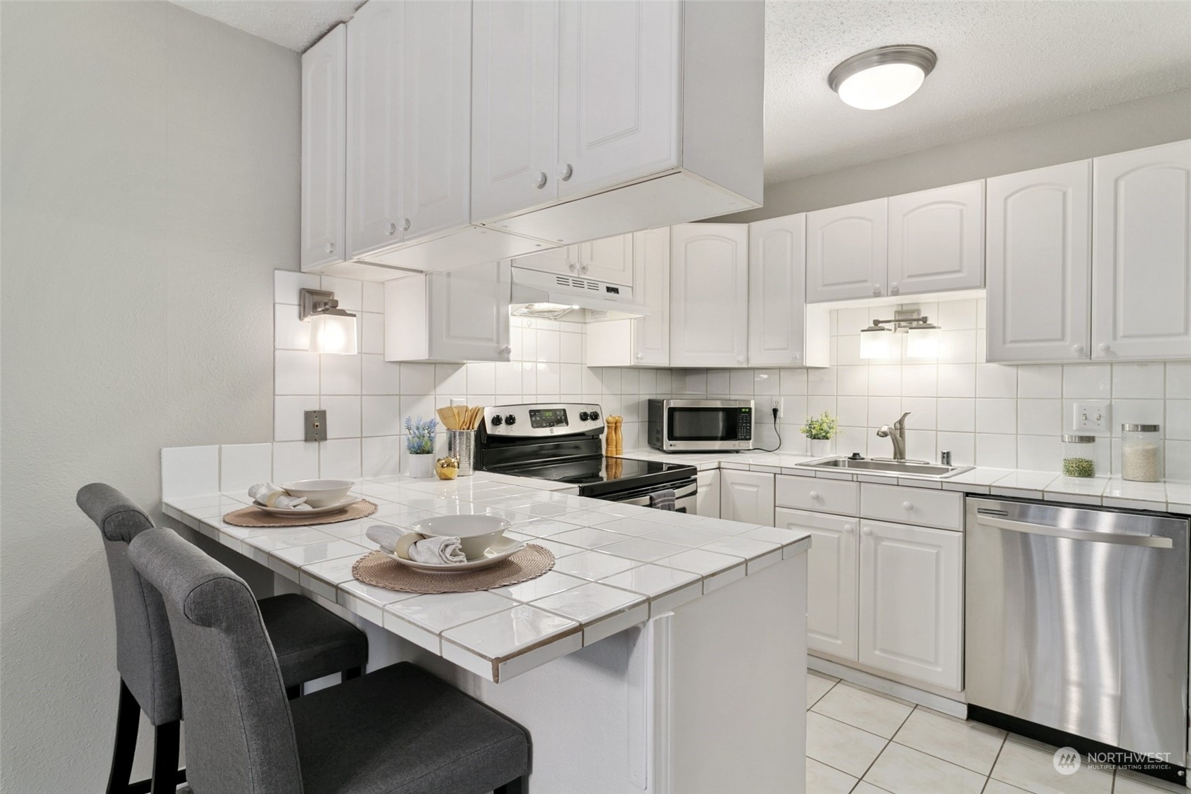 1425 South Puget Drive, Unit H5 Renton, WA 98055 - Photo 12 of 29 a kitchen with white cabinets stainless steel appliances and sink