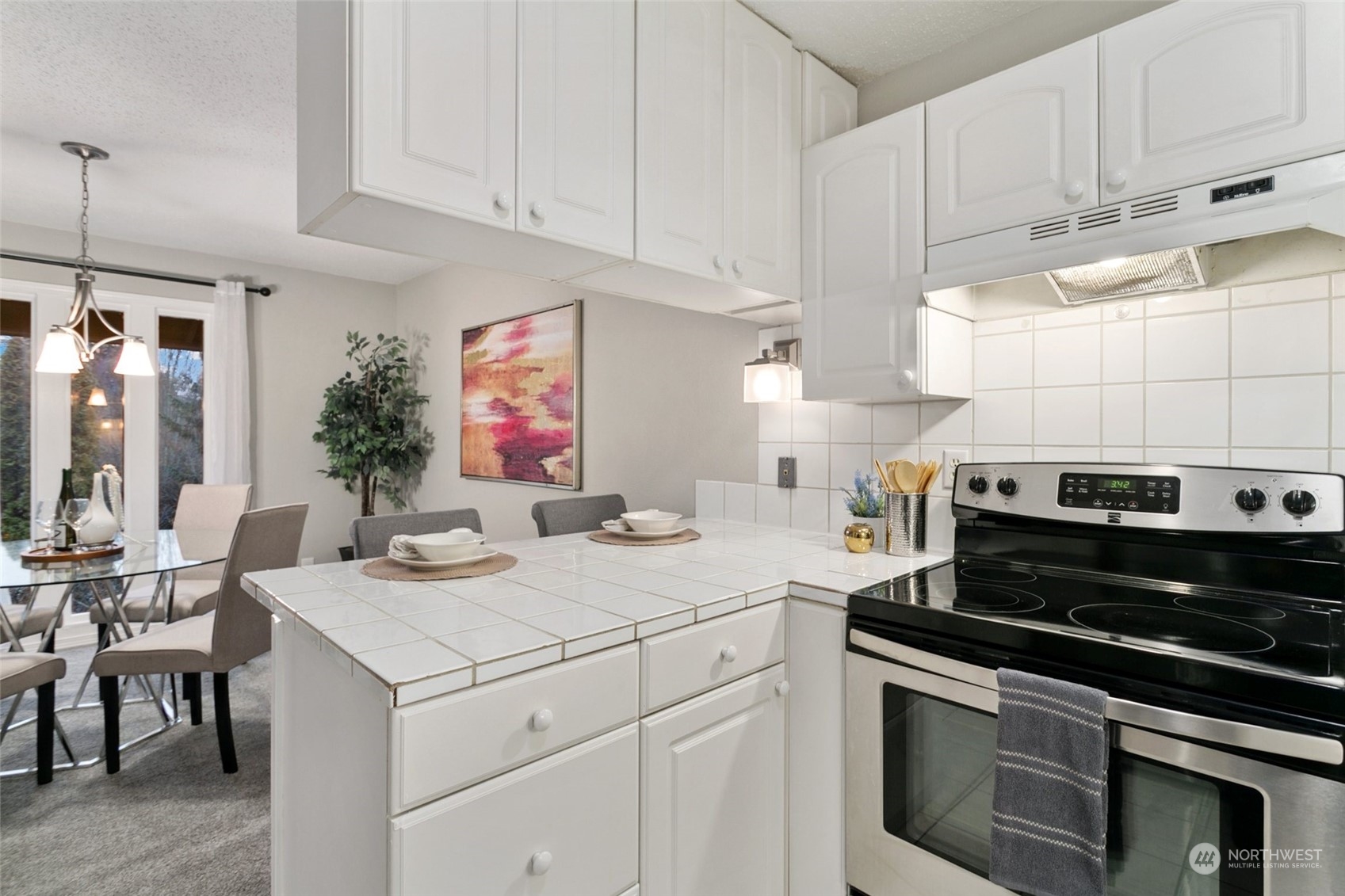 1425 South Puget Drive, Unit H5 Renton, WA 98055 - Photo 13 of 29 a kitchen with a stove and white cabinets