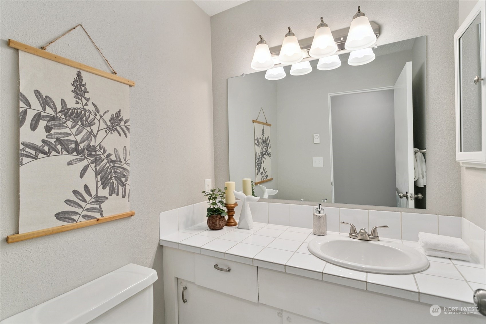 1425 South Puget Drive, Unit H5 Renton, WA 98055 - Photo 15 of 29 a bathroom with a sink a mirror and a chandelier