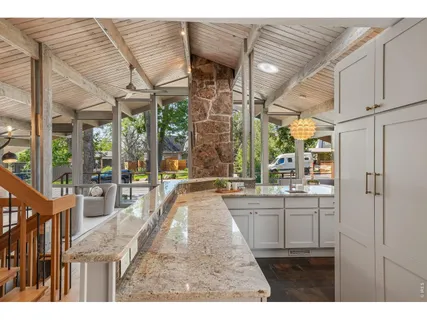 a kitchen view with granite countertop a large window and cabinets