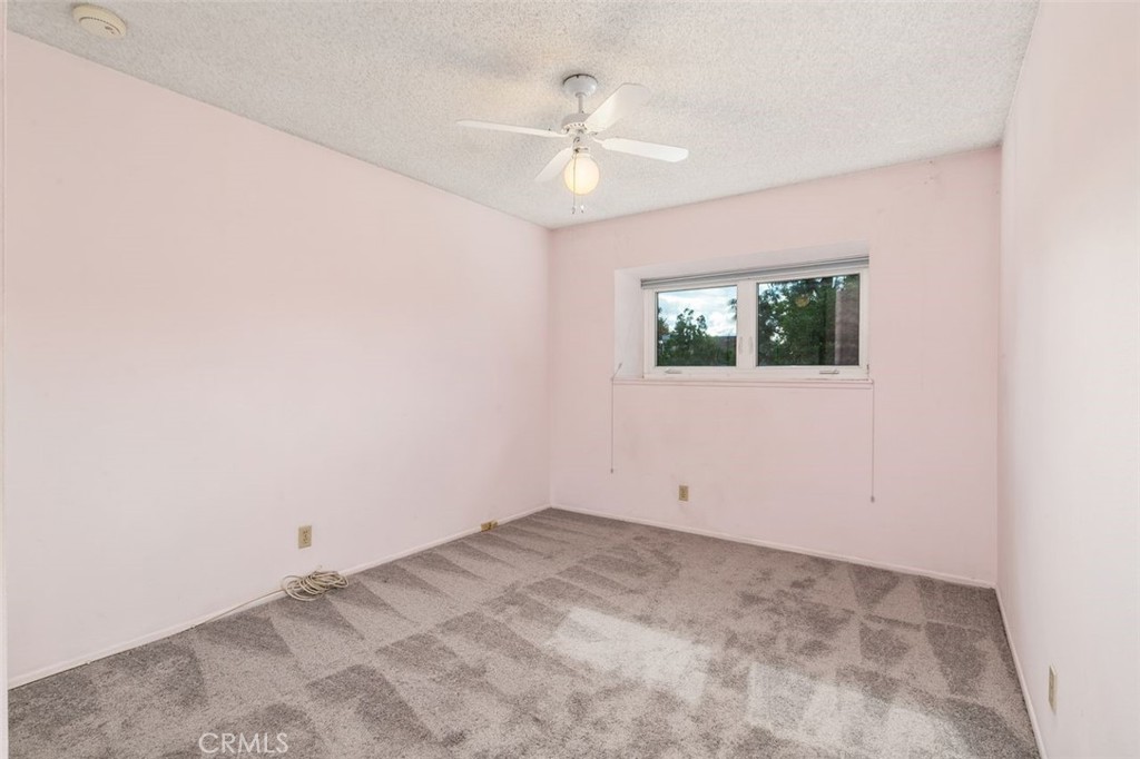 7718 Rambling Brook Way Stanton, CA 90680 - Photo 11 of 23 an empty room with a ceiling fan and window
